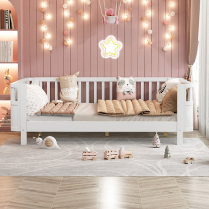 White children's bed with pink bedding in a room decorated with string lights and toys.